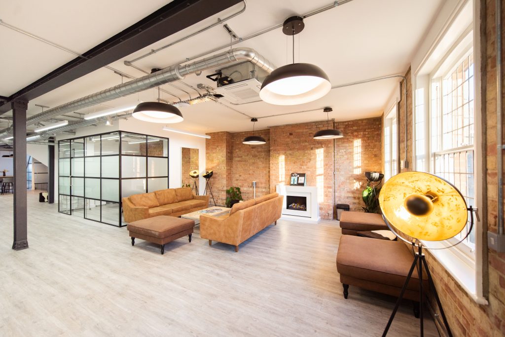 Completed office refurbishment with modern furniture and exposed brick.
